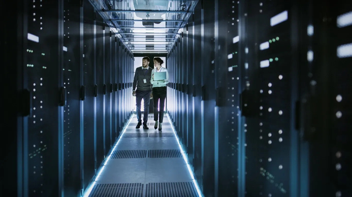 Two technology professionals walking through a data centre